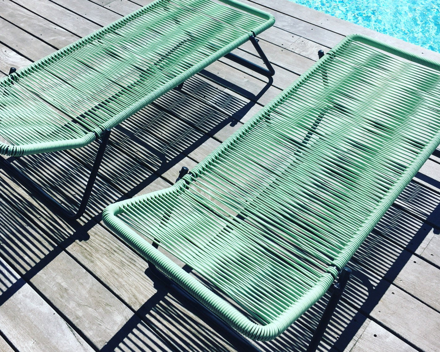 Transat tressés vert au bord d'une piscine